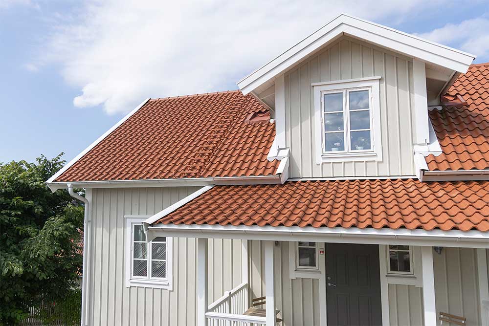 Modernt vitt hus med brunt hustak